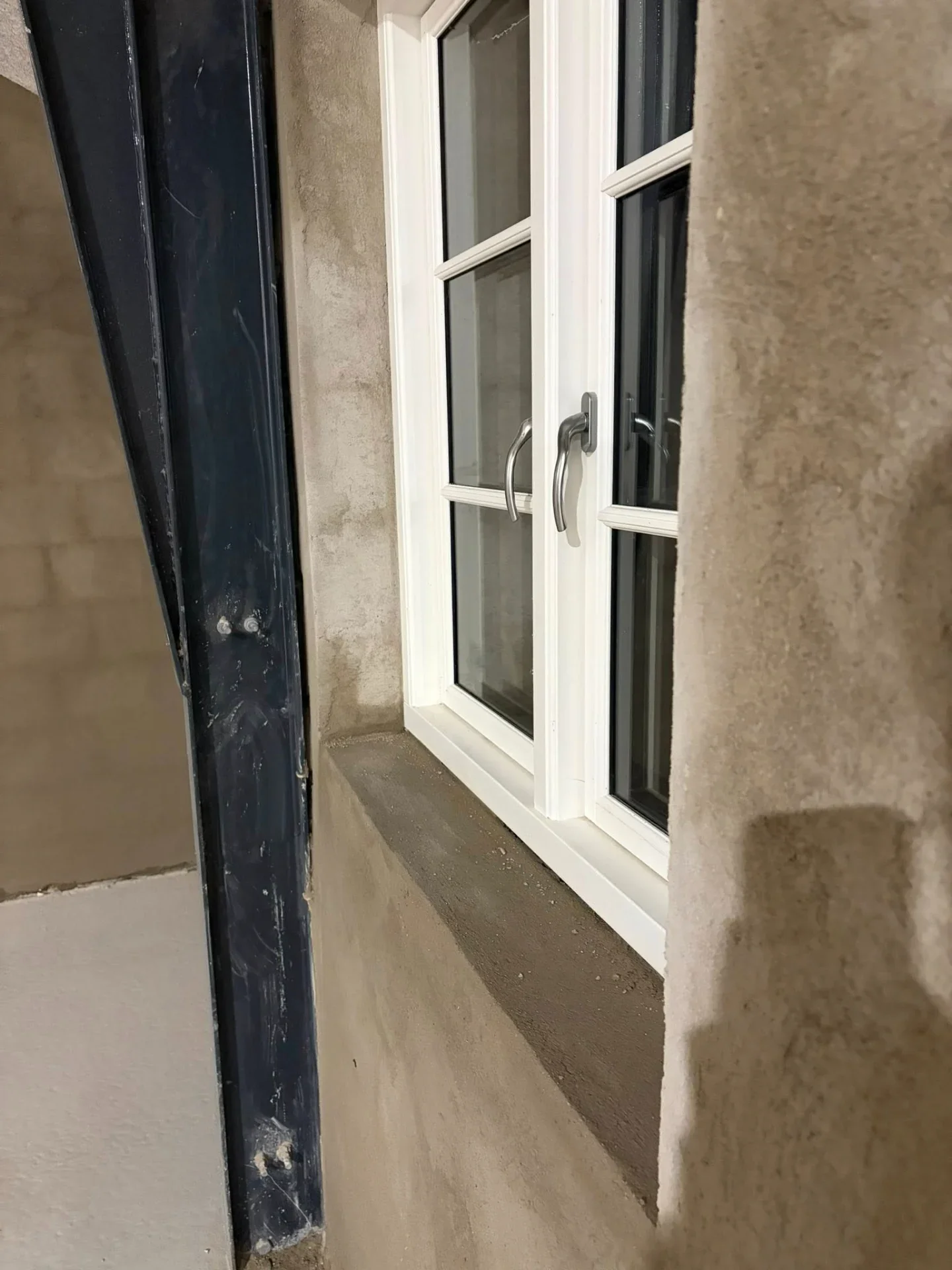Nybygget vindue installeret i væg med isolering og facade.