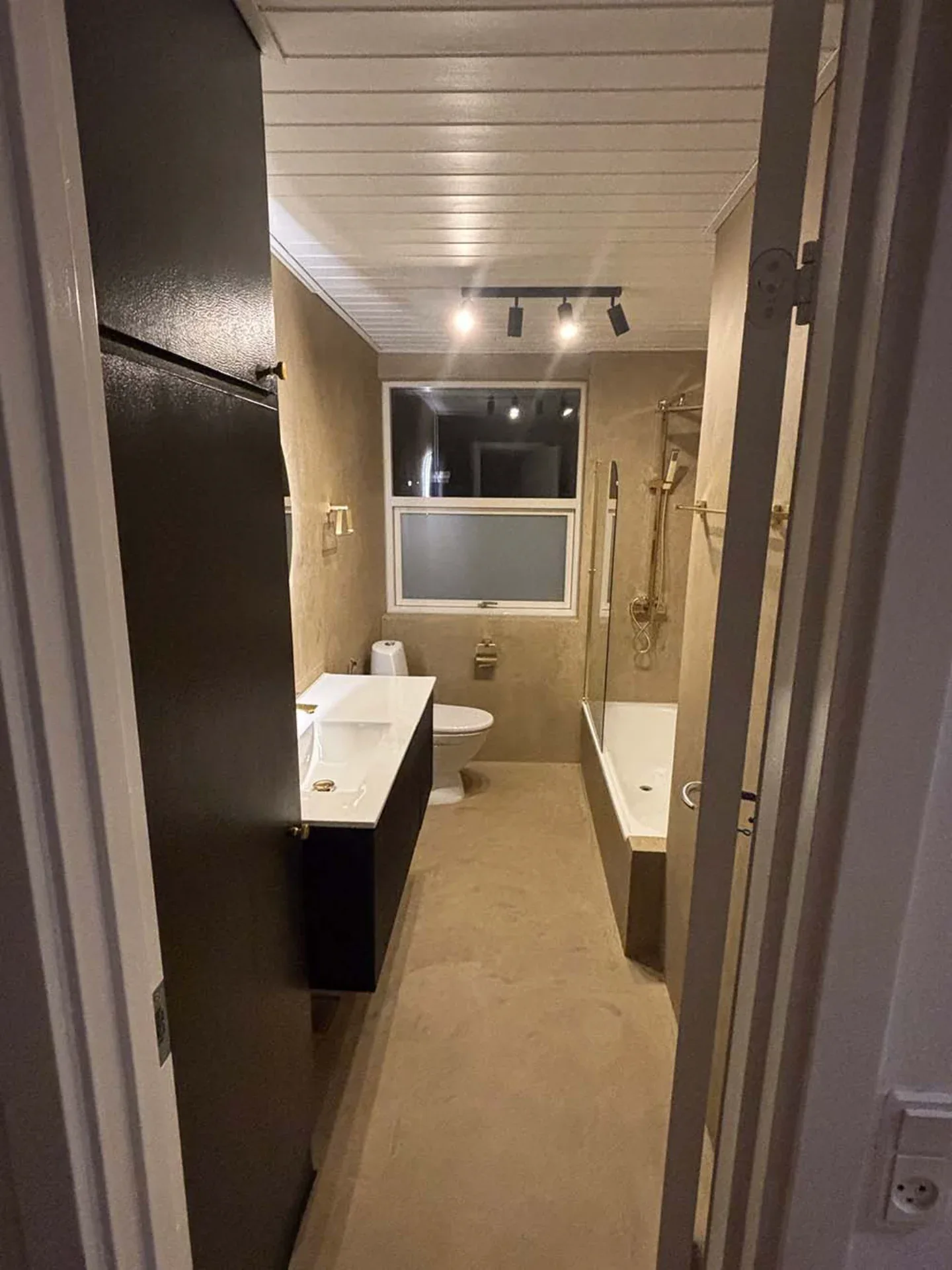 Moderne badeværelse med badekar, vask og toilet i elegant design.