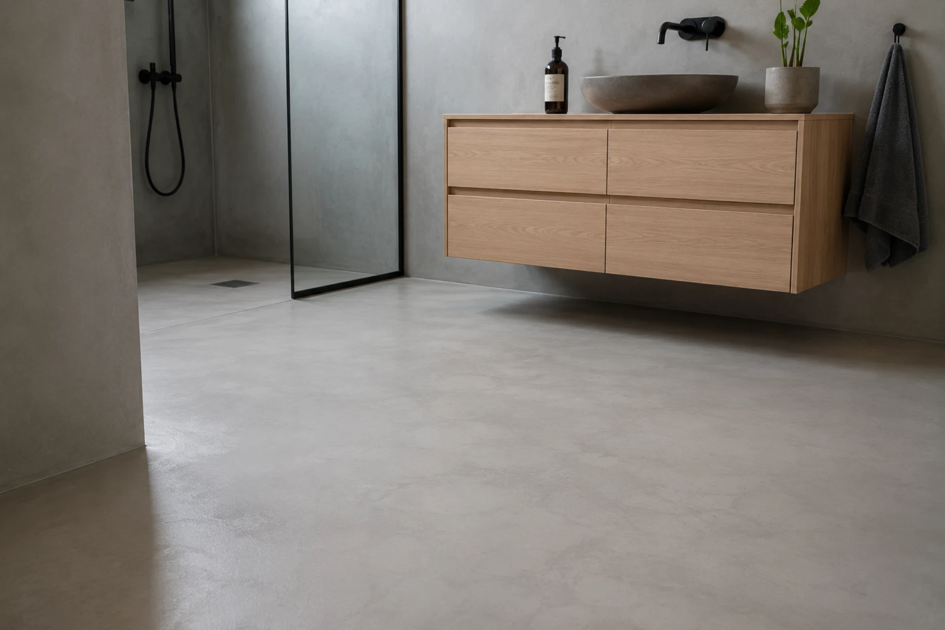 Moderne badeværelse med microcementgulv og minimalistisk design.